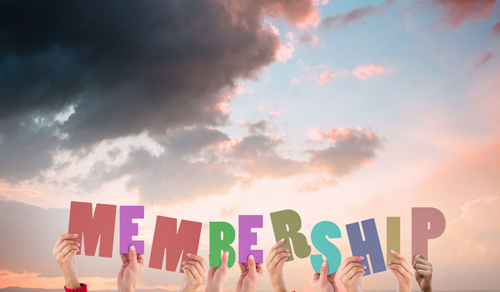 people holding up letters that form the word membership