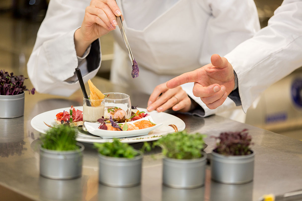 chef teaching a student how to prepare a meal