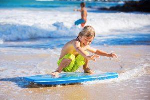 young boy standing on a boogie board