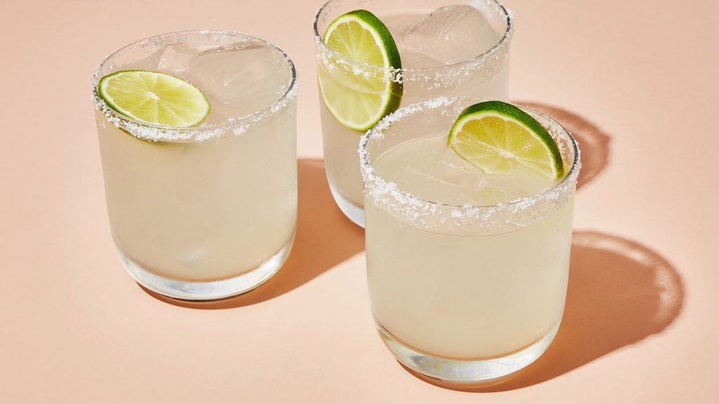 Image of Mojitos with limes in them and sugar around the rim